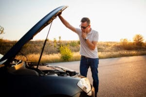 Young man checking car engine